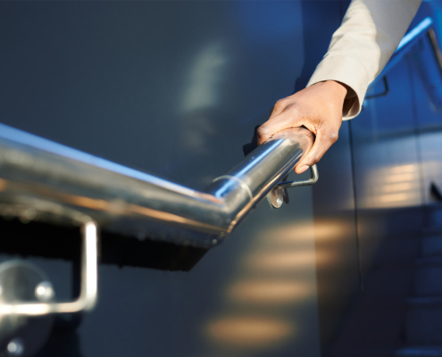 Side view of a man holding a handrail